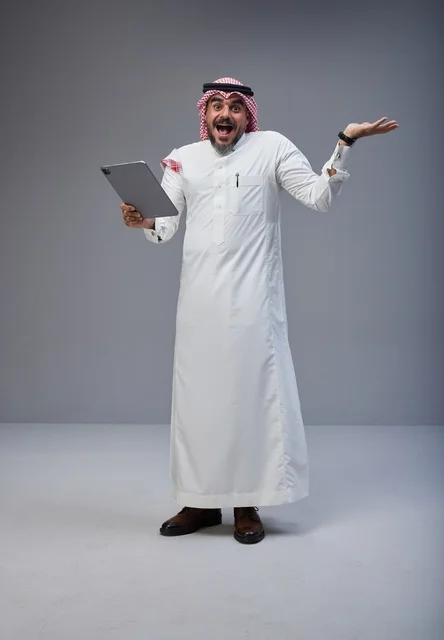 Excited Saudi Man with Tablet in Traditional Dress