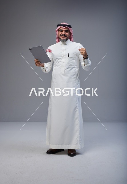Saudi Man with Tablet Celebrating Success in Studio