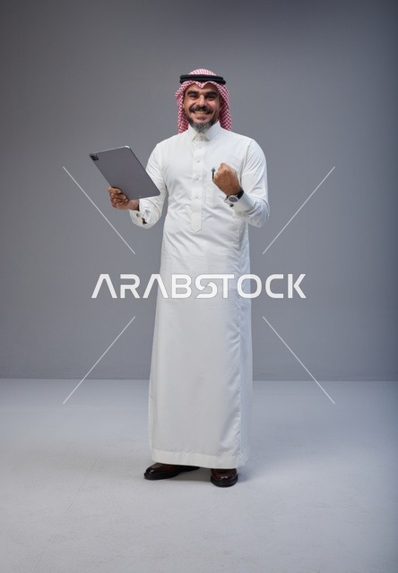 Saudi Man in Thobe Celebrating with Tablet