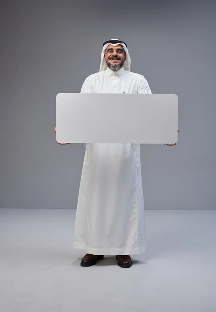 رجل سعودي بالزي التقليدي يحمل لوحة بيضاء فارغة رجل سعودي بالزي التقليدي يحمل لوحة بيضاء فارغة