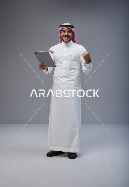 Saudi Man with Tablet Celebrating Success in Studio
