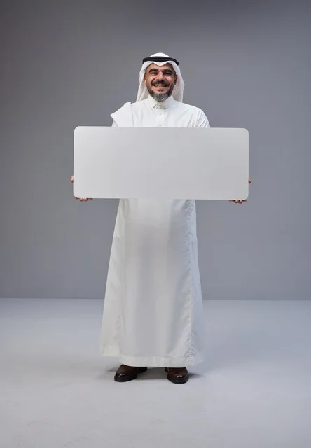 رجل سعودي بالزي التقليدي يحمل لوحة بيضاء فارغة