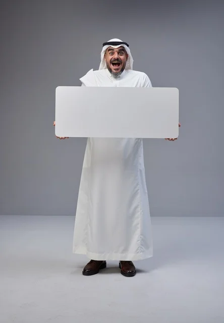 رجل سعودي بالزي التقليدي يحمل لوحة بيضاء فارغة