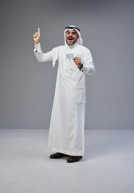 رجل سعودي يحمل بطاقة تعريف فارغة ويشير للأعلى