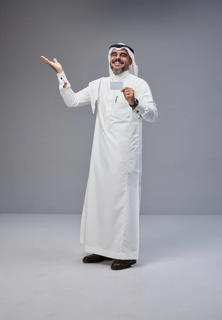 رجل سعودي بالزي التقليدي يحمل بطاقة تعريف فارغة