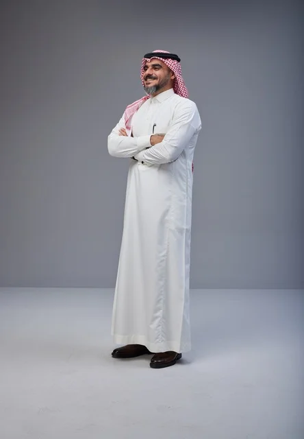 رجل سعودي بالزي التقليدي يقف بثقة في استوديو تصوير