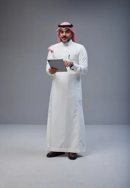 Saudi Man in Traditional Dress Using Tablet in Studio