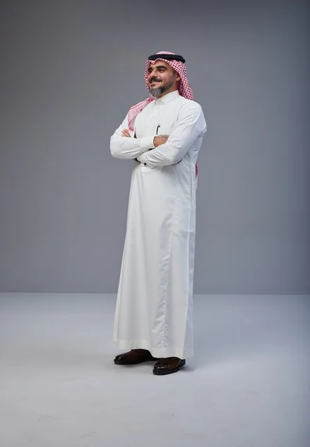 رجل سعودي بالزي التقليدي يقف بوضعية الثقة