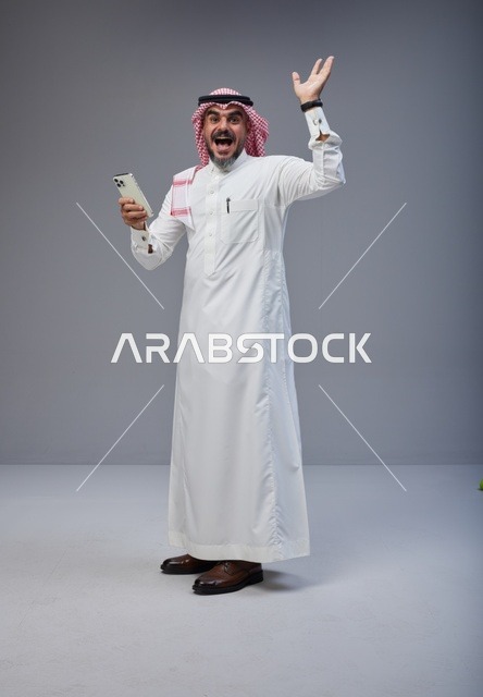 Excited Saudi Man in Thobe Using Smartphone