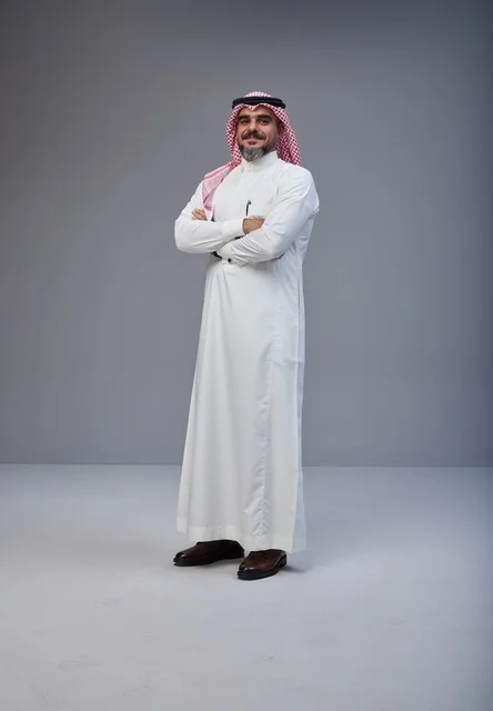 رجل سعودي بالزي التقليدي يقف بثقة في استوديو