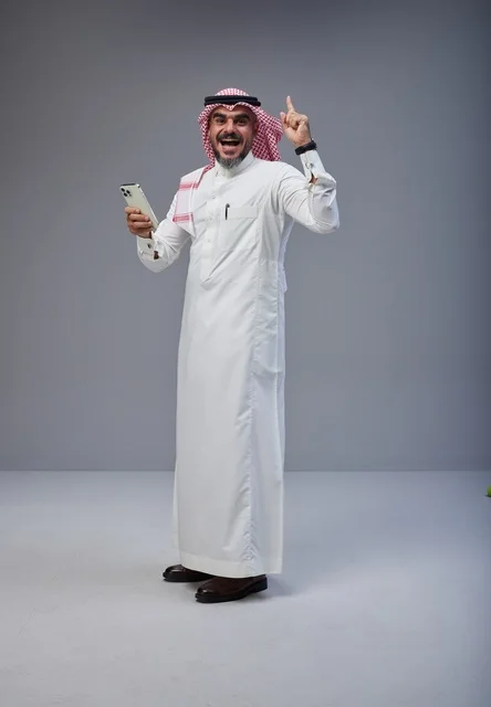 Saudi Man in Thobe Holding Smartphone Pointing Up