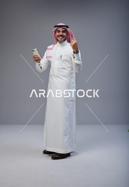 Saudi Man in Traditional Thobe Holding Smartphone
