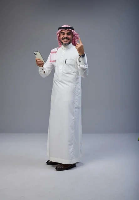 Saudi Man in Traditional Thobe Holding Smartphone