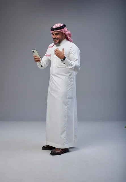 Saudi Man in Traditional Thobe Using Smartphone Saudi Man in Traditional Thobe Using Smartphone