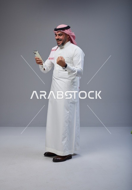Saudi Man Using Smartphone With Victory Gesture