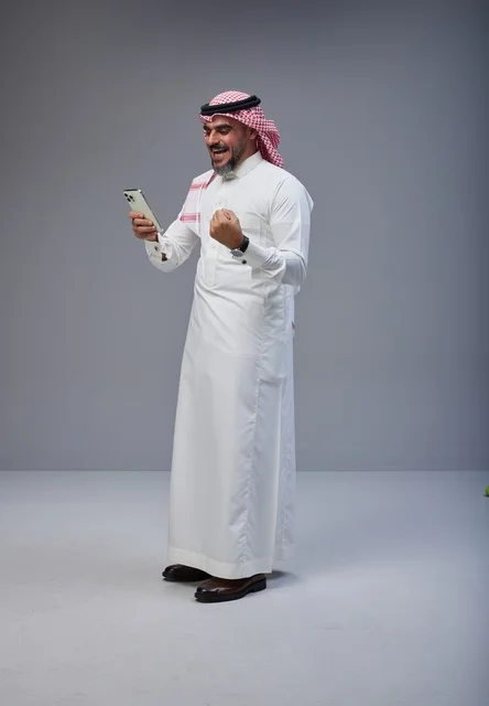 Saudi Man Using Smartphone With Victory Gesture