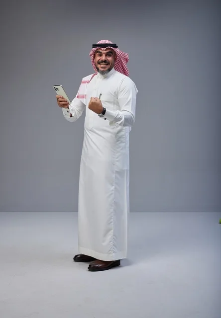 Saudi Man in Traditional Thobe Celebrating with Smartphone