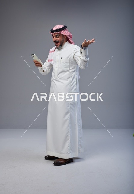 Saudi Man in Traditional Thobe Surprised by Smartphone