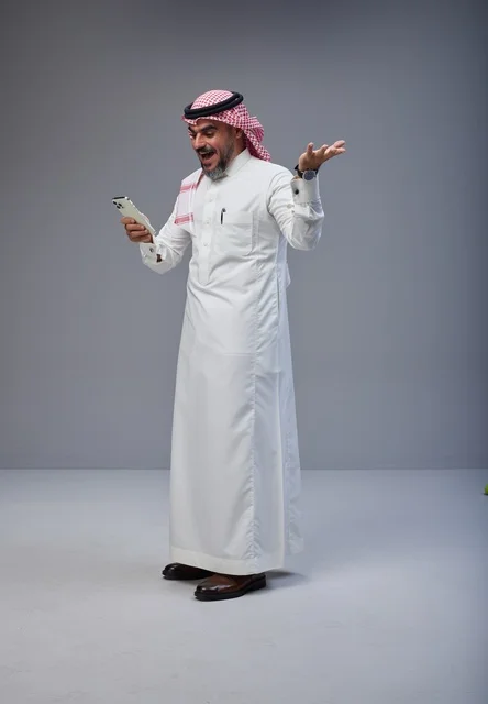 Saudi Man in Traditional Thobe Surprised by Smartphone