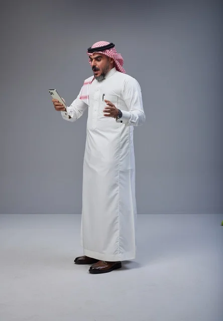 Shocked Saudi Man Looking at Smartphone in Studio