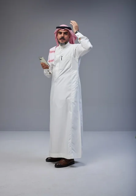 Saudi Man in Traditional Thobe Holding Smartphone
