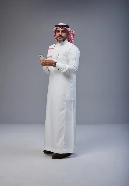 Saudi Man in Traditional Thobe Holding Smartphone