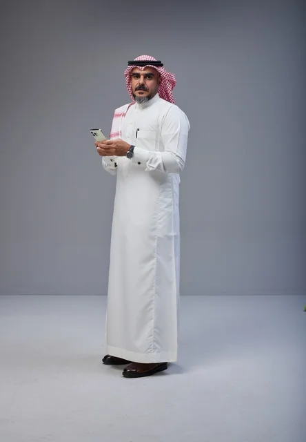 Saudi Man in Traditional Thobe Using Smartphone