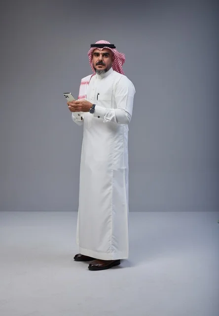 Saudi Man in Traditional Dress Using Smartphone Studio