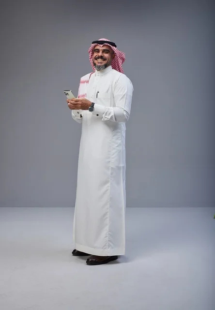 Saudi Man in Traditional Thobe Holding Smartphone