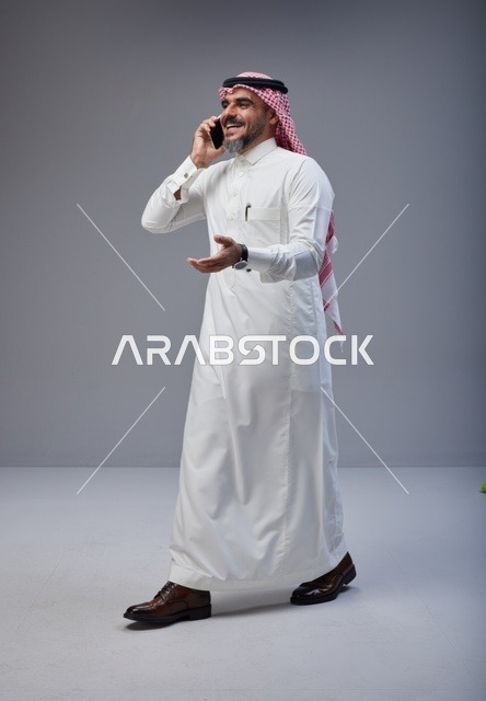 Saudi Man in Thobe Talking on Smartphone Studio