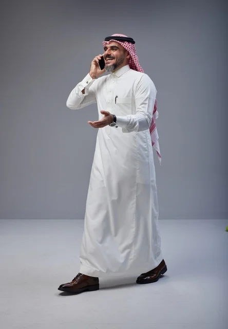 Saudi Man in Thobe Talking on Smartphone Studio