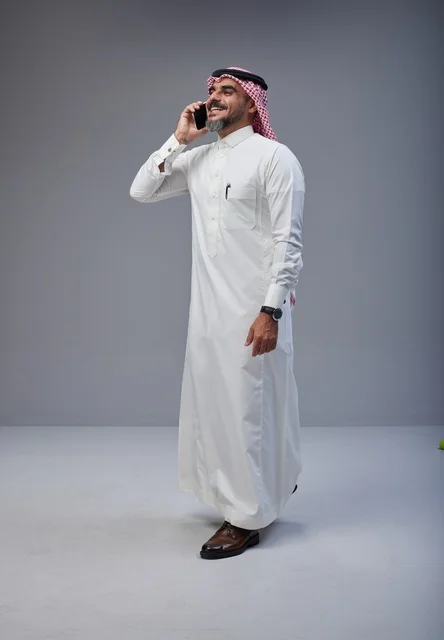 Saudi Man in Traditional Dress Talking on Smartphone