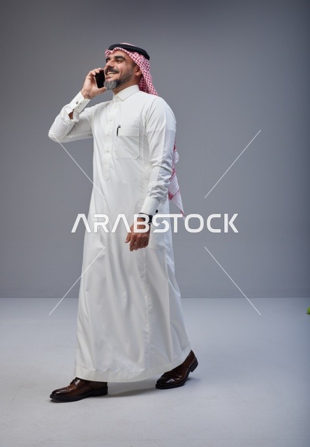Saudi Man in Traditional Thobe Talking on Mobile Phone