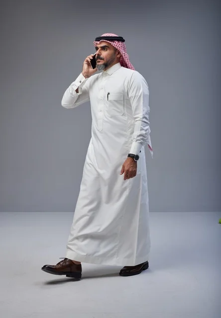 Saudi Man in Traditional Thobe Talking on Phone