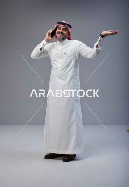 رجل سعودي بالزي التقليدي يتحدث عبر الهاتف