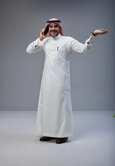Saudi Man in Traditional Dress Talking on Smartphone