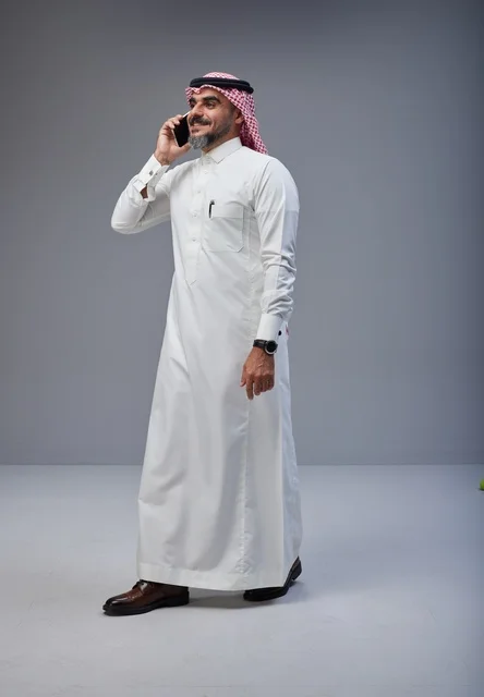 Saudi Man in Traditional Dress Using Smartphone Studio