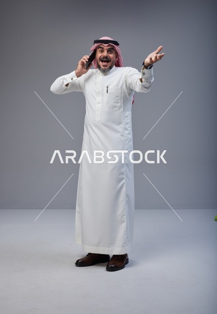 Saudi Man in Traditional Thobe Talking on Mobile Phone