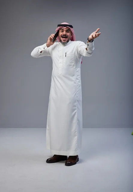 رجل سعودي بالزي التقليدي يتحدث عبر الهاتف المحمول
