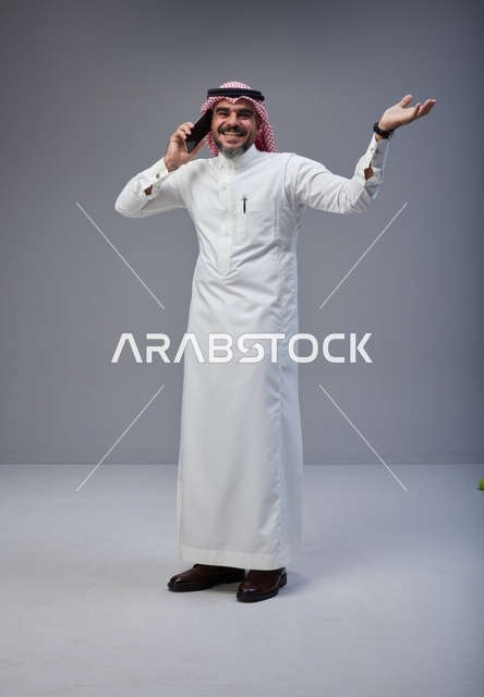 Saudi Man in Traditional Thobe Talking on Phone