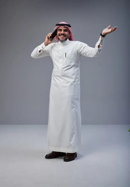Saudi Man in Traditional Thobe Talking on Phone