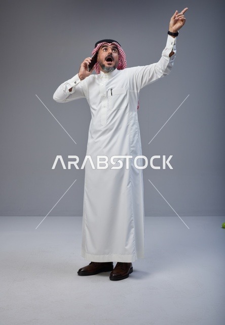 Surprised Saudi Man Talking on Mobile Phone in Studio