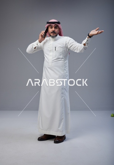 رجل سعودي بالزي التقليدي يتحدث عبر الهاتف