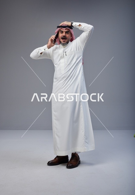 Shocked Saudi Man Talking on Mobile Phone in Studio