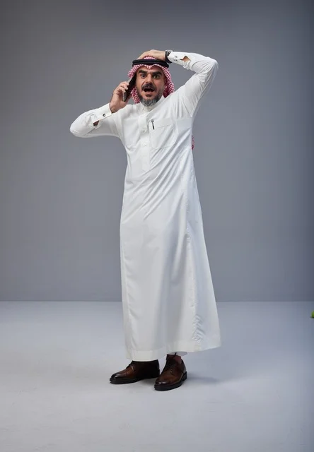 رجل سعودي مصدوم يتحدث عبر الهاتف المحمول في الاستوديو