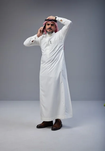 Saudi Man in Traditional Thobe Talking on Phone