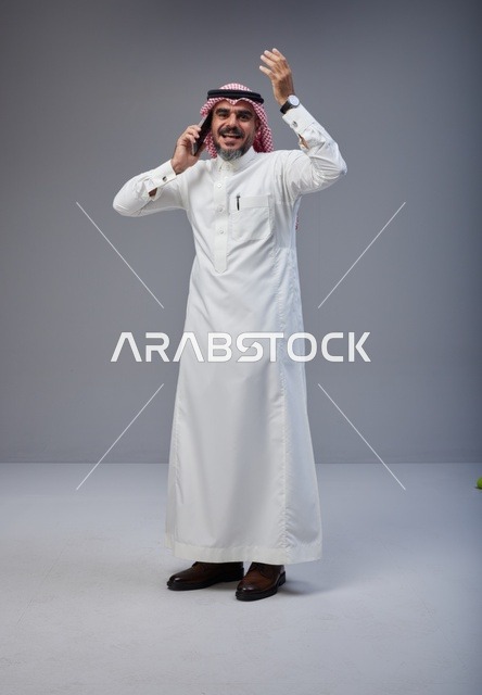 Saudi Man in Traditional Thobe Talking on Smartphone