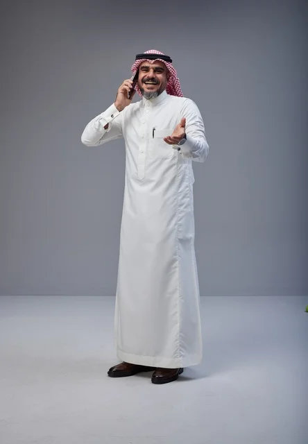 رجل سعودي بالزي التقليدي يتحدث عبر الهاتف المحمول