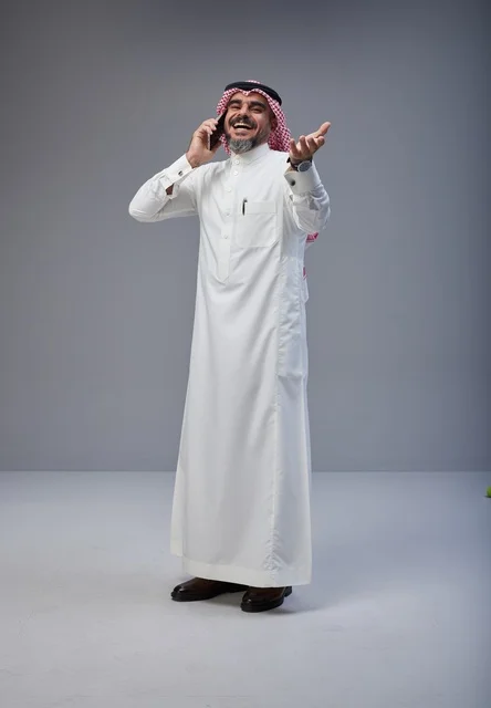 رجل سعودي بالزي التقليدي يتحدث عبر الهاتف المحمول