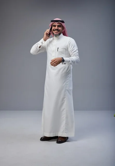 رجل سعودي بالزي التقليدي يتحدث عبر الهاتف الجوال